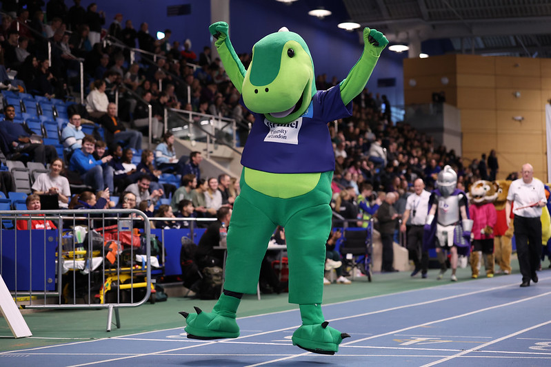 Izzy the mascot jumping up and down looking happy