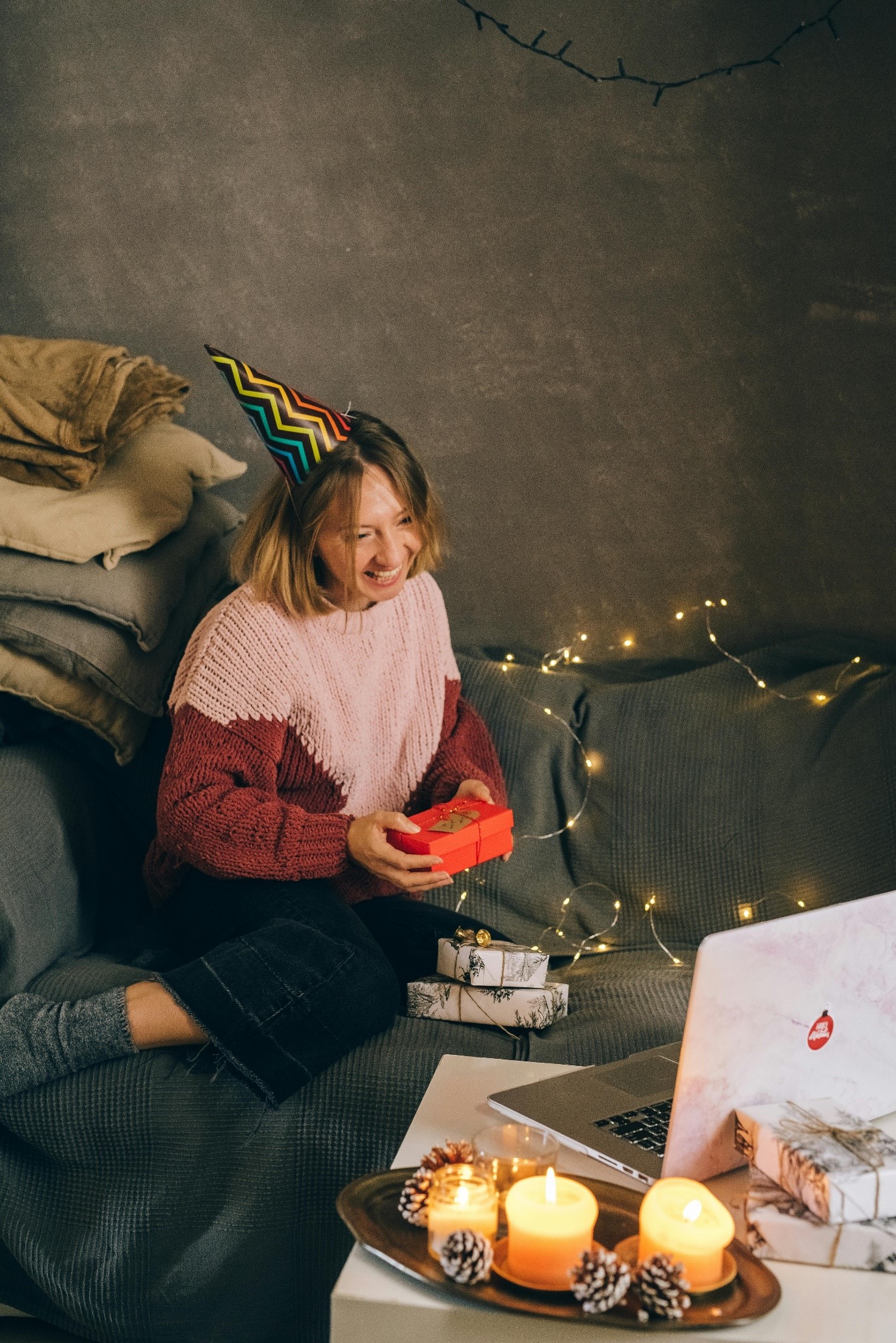 A person sitting on a couch with a birthday hat onDescription automatically generated